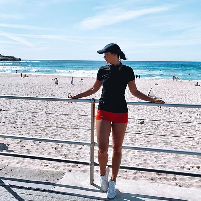 Woman standing at the beach wearing black icebreaker Tech Lite t-shirt