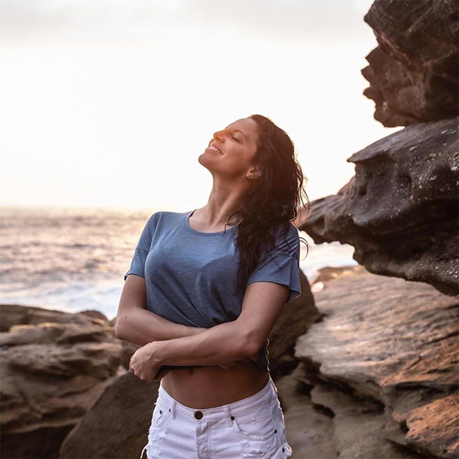 Woman standing at the beach wearing blue icebreaker Cool-Lite™ t-shirt