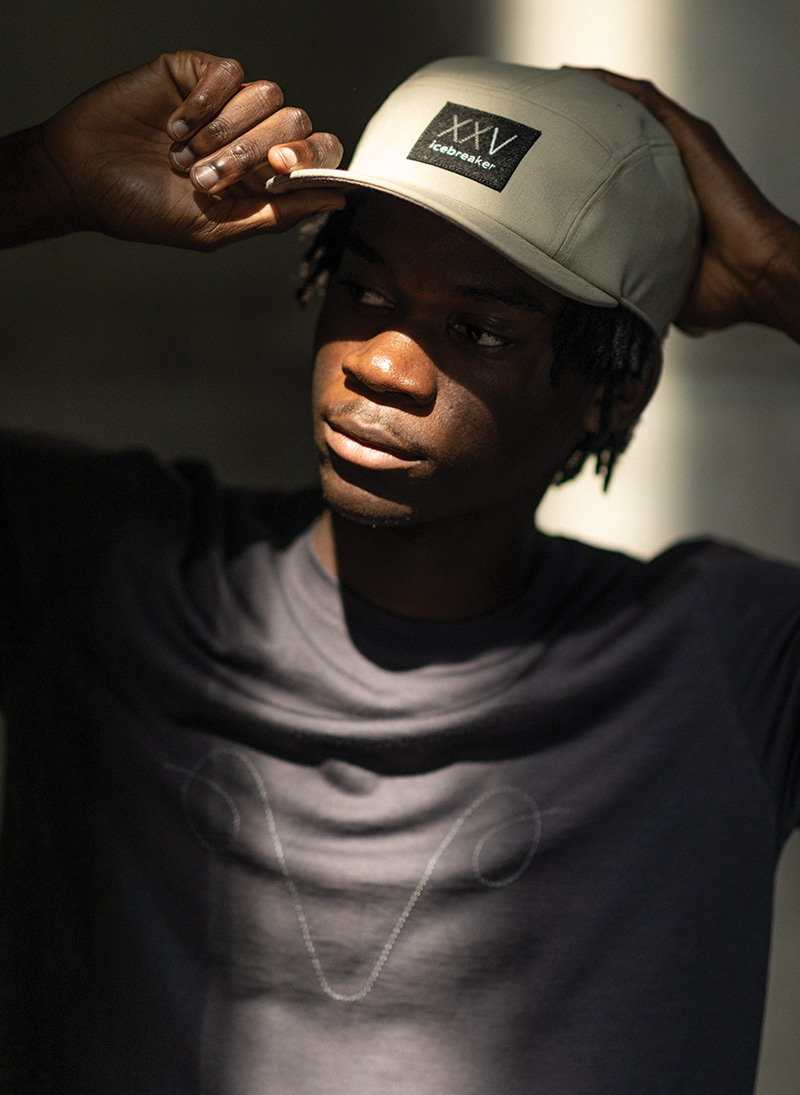 Man standing outside on city street wearing the tan icebreaker XXV collection hat.