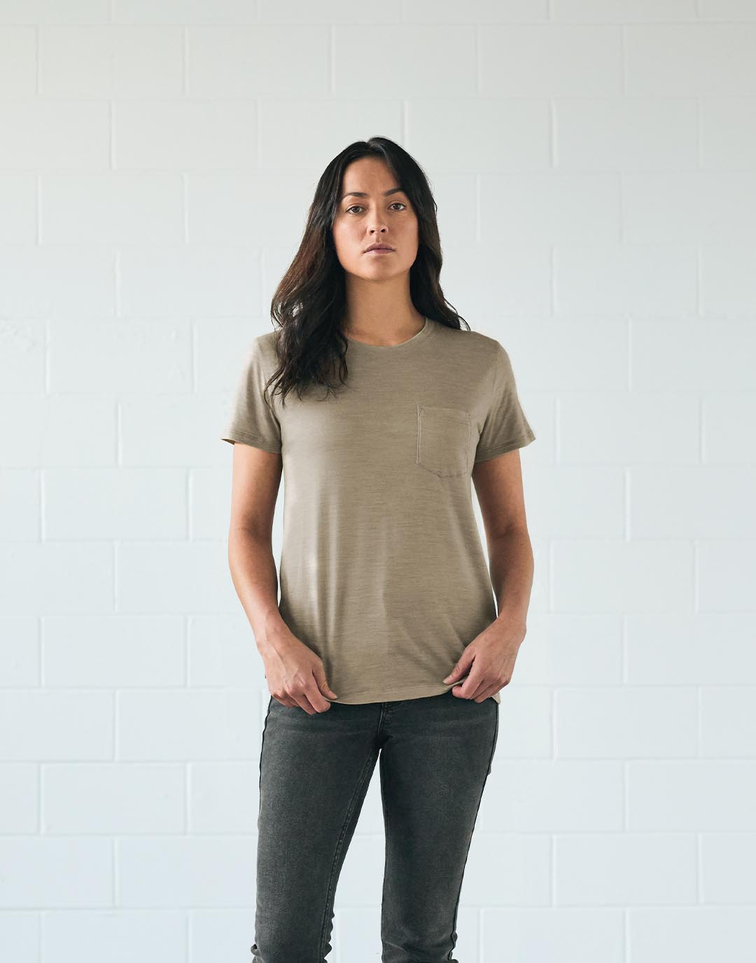 Une femme debout qui porte un t-shirt teint avec des pigments végétaux naturels de provenance durable