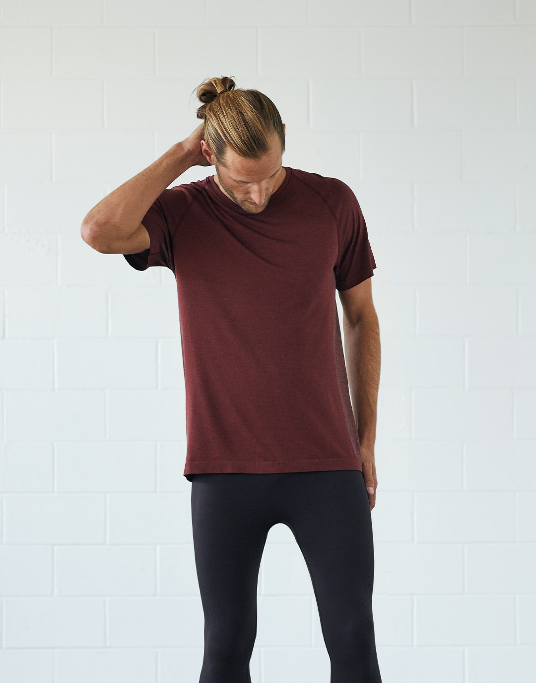 Mann in einem roten T-Shirt und schwarzen Leggings